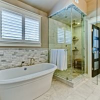 Luxury bathroom remodel featuring freestanding soaking tub, glass walk-in shower, and marble tile by i BUILD KC in Kansas City
