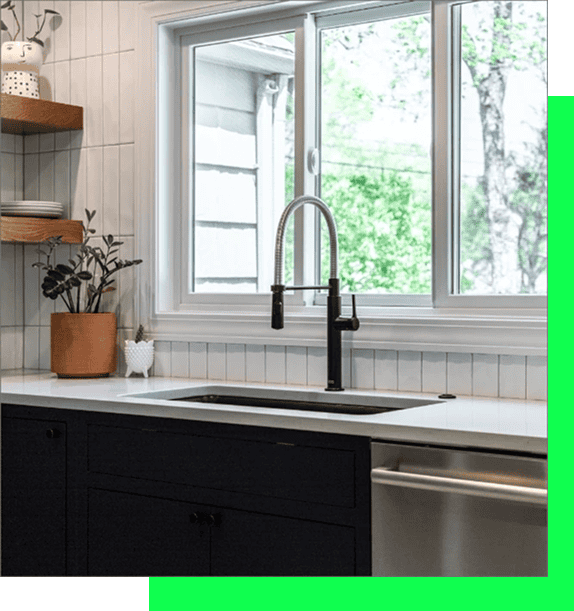 Bright kitchen featuring a large window, modern black cabinets, and a stylish faucet.