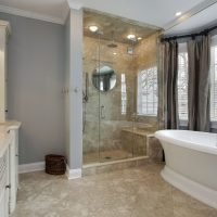 Elegant master bathroom remodel with double vanity, glass shower enclosure, and freestanding soaking tub by i BUILD KC